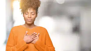 image of a woman holding hand over heart representing dealing with burnout and overcoming burnout